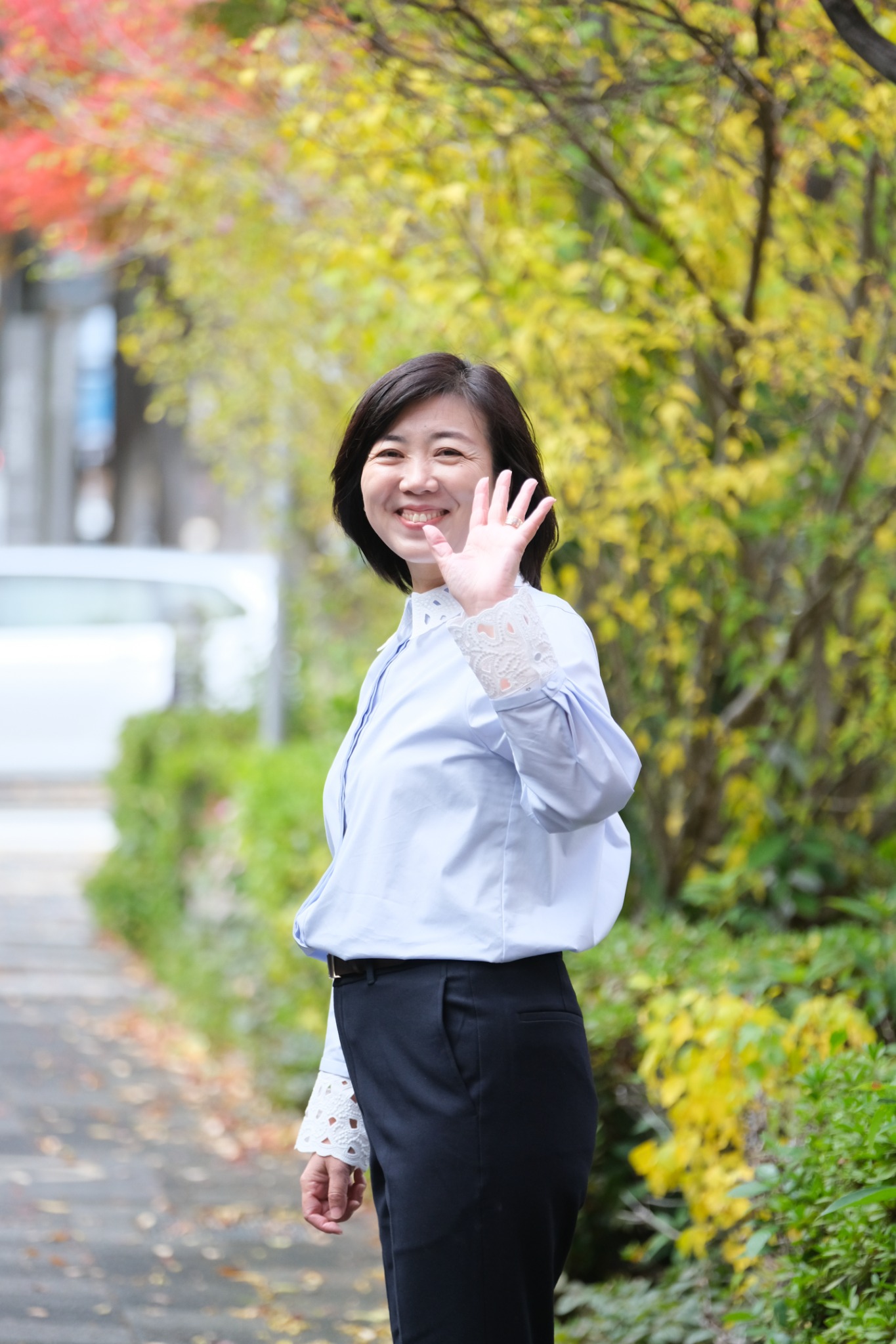 屋外で手を振る広沢まゆみ